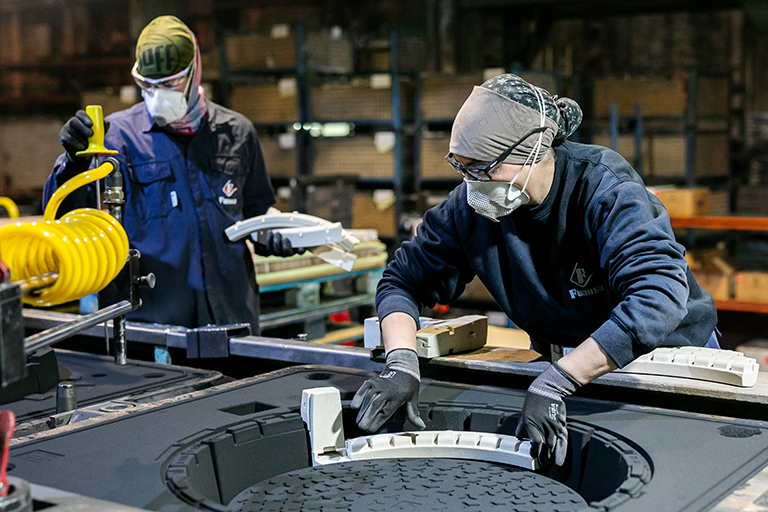 Workers handling molds