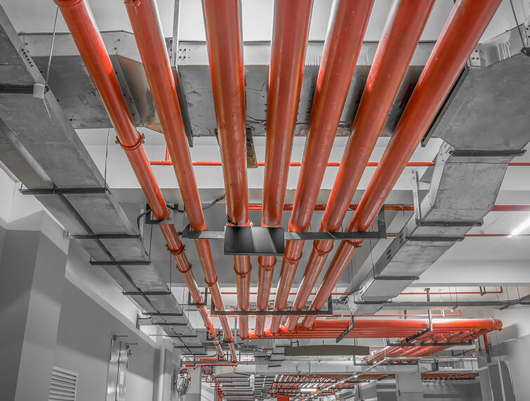 Tuberías industriales rojas instaladas en el techo de un edificio