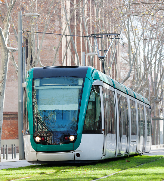Tranvía moderno circulando por una vía urbana con catenaria aérea
